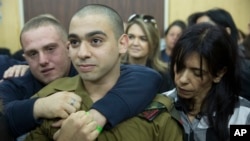 FILE - Israeli solider Sgt. Elor Azaria waits with his parents for the verdict inside the military court in Tel Aviv, Israel on Jan. 4, 2017. 