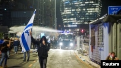 Security forces use a water cannon to disperse the people attending a demonstration against Israeli Prime Minister Benjamin Netanyahu and his nationalist coalition government's plan for judicial overhaul, in Tel Aviv, March 27, 2023. 