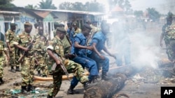 Des miliaires et policiers burundais dégagent d'une voie publique des barricades érigées par des manifestants opposés à un troisième mandat du président Pierre Nkurunziza