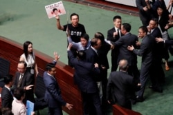 Hong Kong Chief Executive Carrie Lam, far left, leaves after her annual policy address was cancelled due to protests by pro-democracy lawmakers at the Legislative Council in Hong Kong, China, Oct. 16, 2019.