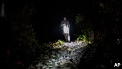 ARCHIVO - Un médico forense analiza una escena de crimen en El Salvador, el 27 de mayo de 2015.