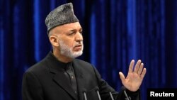 FILE - Afghan President Hamid Karzai speaks during the opening of the Loya Jirga, in Kabul, Nov. 21, 2013. 