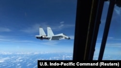 Pesawat tempur J-11 milik Angkatan Laut China terbang mendekati pesawat RC-135 milik militer AS di atas wilayah Laut China Selatan dalam potongan gambar yang diambil dari video pada 21 Desember 2022. (Foto: U.S. Indo-Pacific Command/Handout via Reuters)