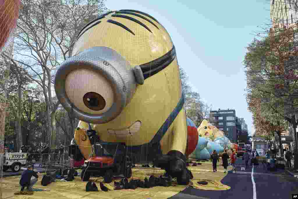 Un hombre toma una foto de un globo de helio inflado de 'Stuart the Minion' el miércoles 23 de noviembre de 2022, en Nueva York, mientras la ciudad se prepara para el Desfile del Día de Acción de Gracias de Macy's.