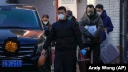 19일 중국 베이징의 고열 전문 병원에서 사망한 환자의 가족들이 시신을 운구하고 있다.