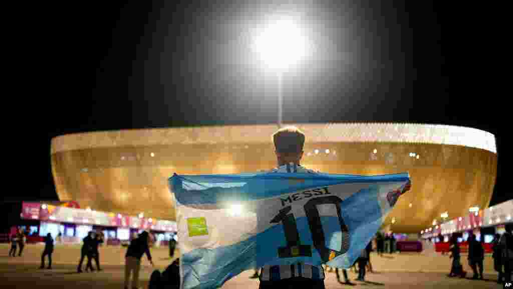 Mokumisi moko alati bendele ya #10 Lionel messi ya Argentine libanda lya stade Lusail, Doha, 9 décembre 2022. (AP Photo/Natacha Pisarenko)