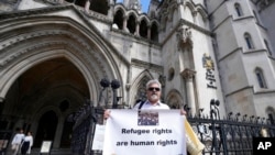 Waandamanaji wakiwa nje ya Mahakama Kuu London, Ijumaa, Juni 10, 2022. (AP Photo/Frank Augstein)