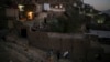 FILE - Afghans carry supplies to their home at dusk in Kabul, Afghanistan, Sept. 14, 2021. 