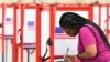 A voter fills out her ballot during the Kentucky Primary at the Kentucky Exposition Center in Louisville, Ky., June 23, 2020. 
