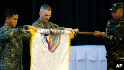 Philippine Navy Vice-Admiral Alexander Lopez, left, and U.S. Marine Brig. Gen. Christopher Mahoney, center, unfurl the Balikatan flag during the exercise's opening ceremony Monday, April 20, 2015 at Camp Aguinaldo at suburban Quezon city, northeast of Manila, Philippines. (AP Photo/Bullit Marquez)