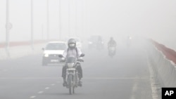 Motorists surrounded by smog, in New Delhi, India, Nov. 8, 2017. The Indian Medical Association said New Delhi was in the midst of a "public health emergency" and appealed to the city government to halt sports and other outdoor activities in schools. (AP Photo/Altaf Qadri)