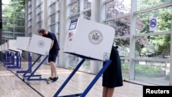 U.S. Rep. Alexandria Ocasio-Cortez (D-NY) and her partner, Riley Roberts, vote early in the Democratic congressional primary election at the Justice Sonia Sotomayor Community Center in the Bronx borough of New York City, June 20, 2020. 
