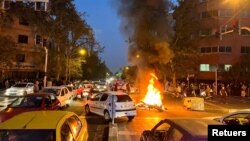 Una motocicleta de la policía arde en una calle de Teherán durante una protesta por la muerte de una joven arrestada por la policía de la moral, el 19 de septiembre de 2022.