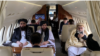 Menteri Luar Negeri Afghanistan Amir Khan Muttaqi (kiri) dan juru bicara kementerian Abdul Qahar Balkhi (tengah) bersama para delegasi Taliban lainnya terlihat dalam pesawat menuju Oslo, Norwegia, di Bandara Kabul pada 22 Januari 2022. (Foto: AFP)