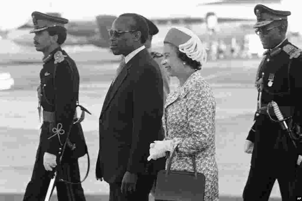 Queen Elizabeth II of England is escorted by Botswana President, Sir Seretse Khama, and his son Brig. Gen Ian Khama on her arrival in Gaberone, Botswana on July 25, 1979, the third stop on the Queen's four-nation Africa tour. (AP Photo)