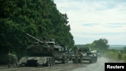Українські військові підбирають російський танк захоплений під час наступу в Харківській області 11 вересня 2022 р. Західні коментатори кажуть, що наступним кроком у військовій допомозі Заходу Україні має стати надання сучасної західної бронетехніки, включно з танками.