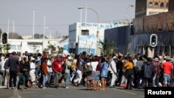 Stick-wielding protesters march through the streets as violence following the jailing of former South African President Jacob Zuma spread to the country's main economic hub in Johannesburg, South Africa, July 11, 2021.