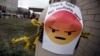 FILE - A sign with an emoji that reads "Don't take net neutrality away" is posted outside the Federal Communications Commission (FCC), in Washington, Dec. 14, 2017.