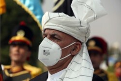 Afghan President Ashraf Ghani sings the national anthem at the Independence Minaret monument during the Independence Day celebrations at the Defense Ministry in Kabul, Afghanistan, Aug. 18, 2020.