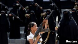 دختر نوجوانی در میان رژه زنان هوادار حوثی ها در صنعا در یمن سلاح در دست گرفته است. ۶ سپتامبر ۲۰۱۶