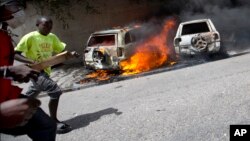 
Orang-orang berlarian setelah mobil-mobil dibakar dekat hotel Best Western dalam unjuk rasa menentang kenaikan harga bahan bakar minyak di Port-au-Prince, Haiti, 7 Juli 2018.
