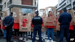 FILE - Members of Reporters Without Borders hold stencils representing portraits of imprisoned Turkish journalists, during a demonstration in front of the Turkish Embassy, in Paris, Jan. 5, 2018. 