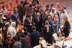 Abdullah Abdullah (C), Chairman of Afghanistan's High Council for National Reconciliation, speaks with negotiators at the end of a session during peace talks between the Afghan government and the Taliban, in Doha, Qatar, Sept. 12, 2020.