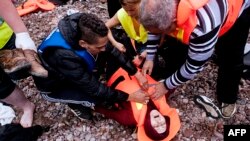 Біженка знепритомніла після прибуття з Туреччини до узбережжя о. Лесбос, Греція. 22 вересня 2015 р.