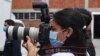 Una fotoperiodista usa una máscara quirúrgica durante una conferencia de prensa en San Salvador, el 21 de abril de 2020.