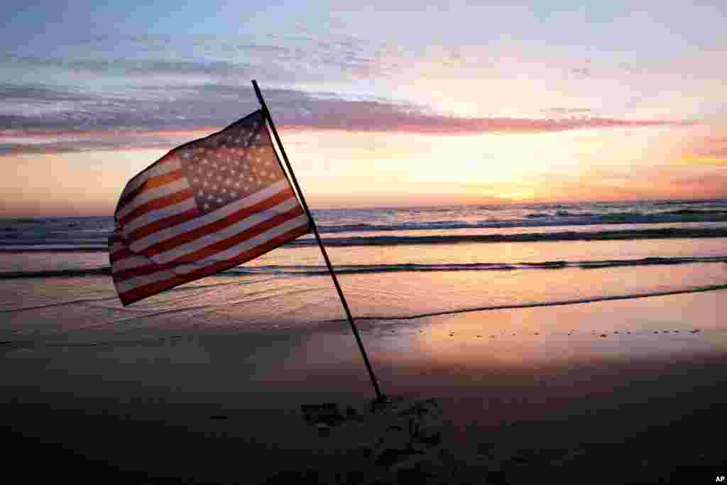 An American flag is placed in the sand of Omaha Beach, western France, as world leaders, veterans and Normandy residents pay tribute to the thousands who gave their lives in the D-Day invasion of Nazi-occupied France 70 years ago, June 6, 2014.