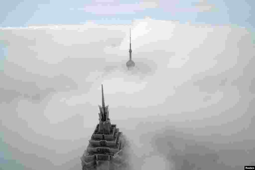 អគារខ្ពស់កប់ពពកពីរ គឺ Oriental Pearl Tower និង Jin Mao Tower (ខាងមុខ) ត្រូវបានមើលឃើញពីមជ្ឈមណ្ឌលហិរញ្ញវត្ថុពិភពលោកសៀងហៃក្នុងសង្កាត់ Pudong ទីក្រុង Shanghai ប្រទេសចិន។