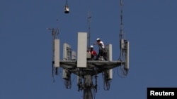 Radnici instaliraju 5G telekonunikacionu opremu na stubu T-Mobile u Seabrooku, Texas, 6. maj 2020.
