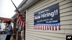 FILE - A sign advertising employment hangs outside a restaurant in Middleton, Massachusetts, July 24, 2017.