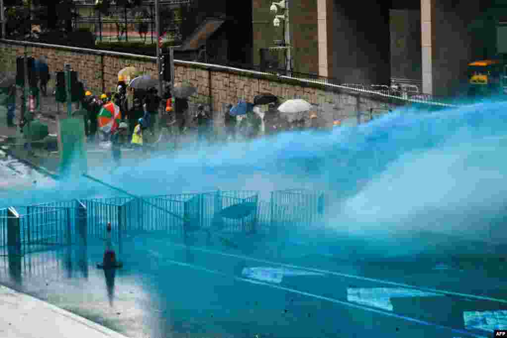 警察在香港政府总部外向抗议者释放带蓝色染剂的水炮。(2019年8月31日)