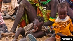 Wanawake wa kabila la Turkana na watoto wao wakisubiri kugawiwa chakula cha msaada karibu na kambi ya wakimbizi ya Kakuma, Wilaya ya Turkan, kaskazini magharibi ya mji mkuu wa Kenya, Nairobi, August 8, 2011. 
