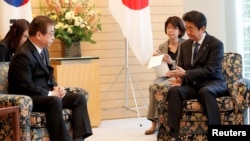 日本首相安倍晋三（右）在东京会晤到访的韩国国家情报院长徐薰。（2018年3月13日）
