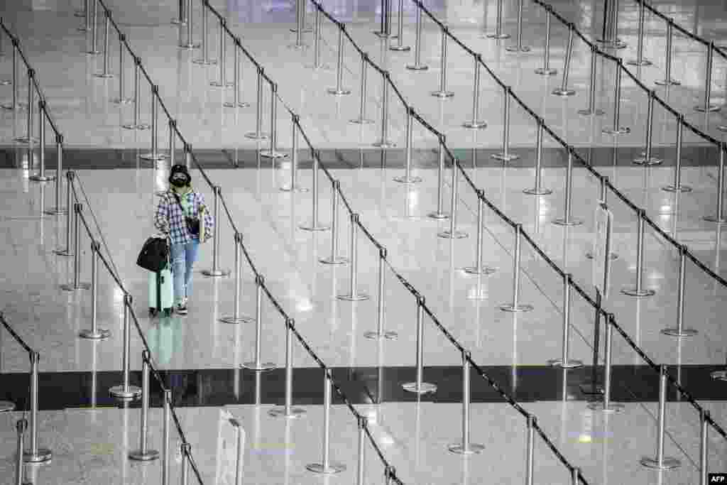 A woman arrives at Hong Kong International Airport before making her way to hotel quarantine. Hong Kong announced on September 23 it will end mandatory hotel quarantine, scrapping some of the world's toughest travel restrictions.