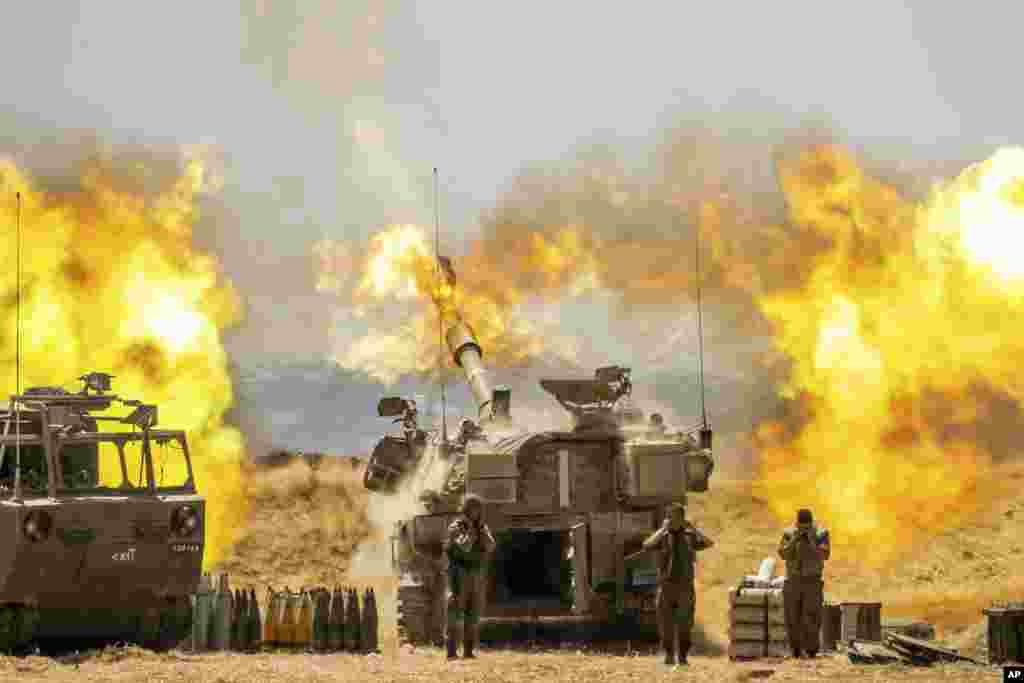 An Israeli artillery unit fires toward targets in Gaza Strip, at the Israeli Gaza border.
