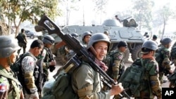 Cambodian soldiers carry their weapons near Preah Vihear temple along the border with Thailand, February 6, 2011.