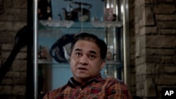 In this Feb. 4, 2013 photo, Ilham Tohti, an outspoken scholar of China's Turkic Uighur ethnic minority, pauses during an interview at his home in Beijing, China.
