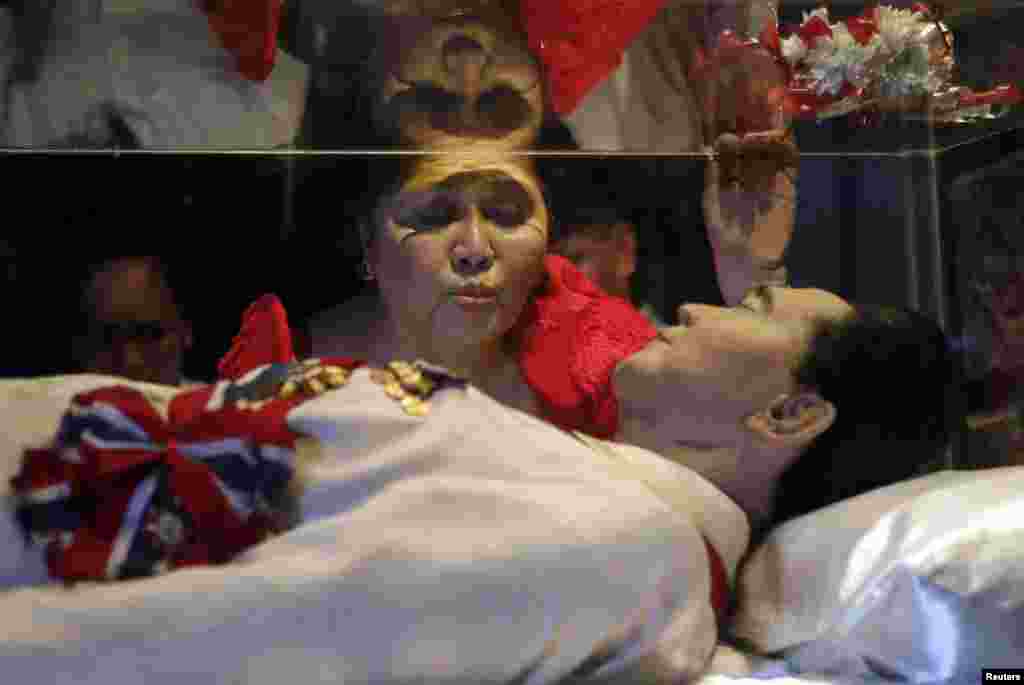 Imelda Marcos mencium kaca peti jenazah suaminya, mendiang Presiden Filipina, Ferdinand Marcos, yang tidak dikuburkan sejak meninggal tahun 1989 di Batac, Ilocos Norte, Filipina.