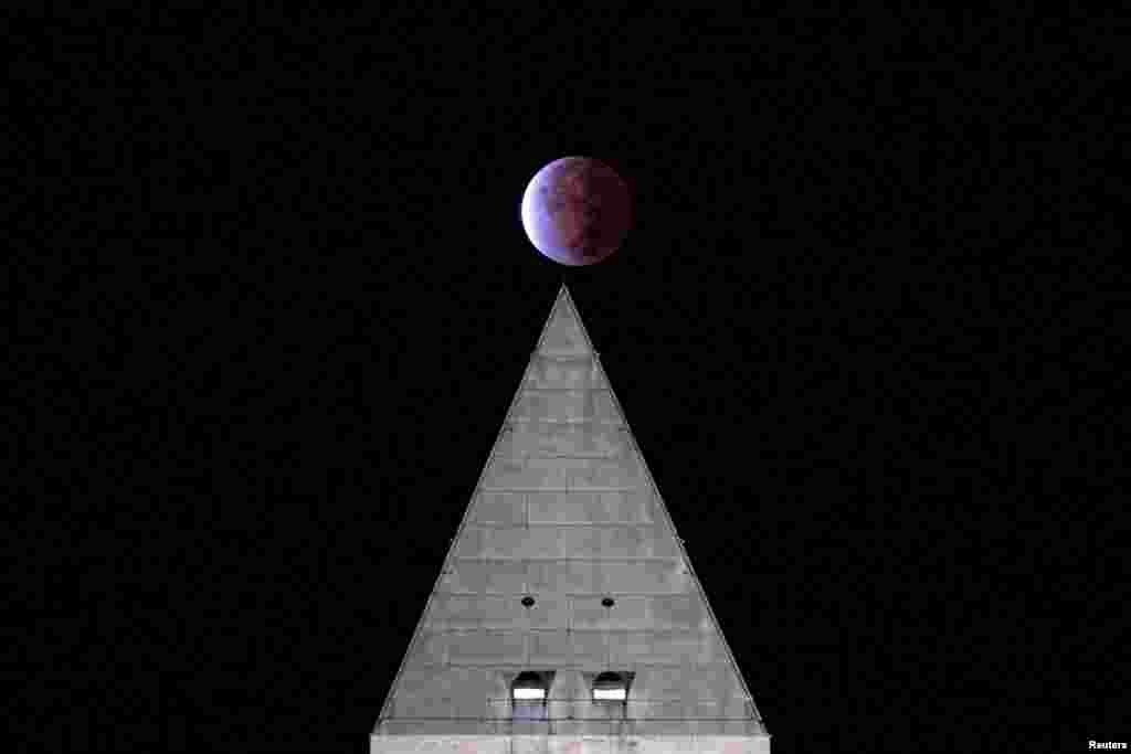 The Beaver Blood Moon partial lunar eclipse is seen above the Washington Monument in Washington.