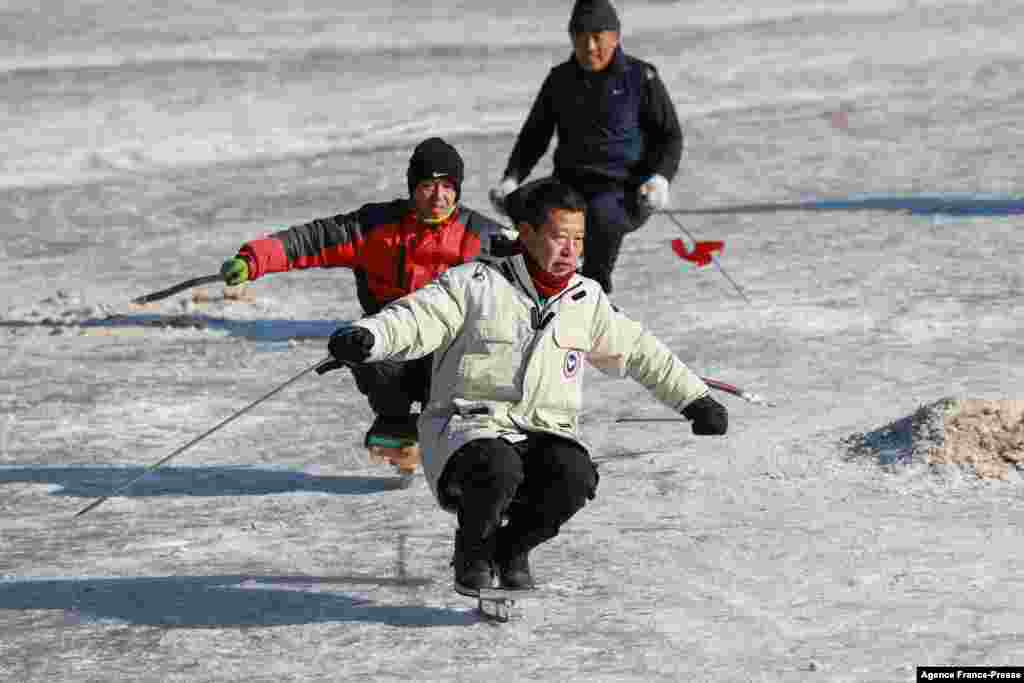 Residents skate on a frozen lake in Shenyang in China's northeastern Liaoning province, Jan. 11, 2022.