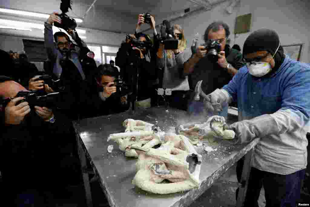 A worker cracks the mold of "The Actor" statuette during a media event on the production of the statuettes for the 24th annual Screen Actors Guild Awards at American Fine Arts Foundry in Burbank, California, Jan. 9, 2018.