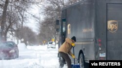 Mike Charnesky, que trabaja de forma remota, ayuda a un camión de reparto de UPS que está atascado en Detroit, Michigan, Estados Unidos, 16 de febrero de 2021.