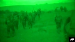 Imágen de video a través de un visor nocturno divulgado por el ejército israelí que muestra tropas de Israel caminando en Gaza.