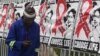 A man makes a call on a mobile phone as he passes past a World AIDS Day banners on the perimeter of an office building in Sandton, Johannesburg, South Africa, Dec. 1, 2014. 