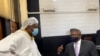 Journalist Hopewell Chin'ono talks to Harrison Nkomo of Zimbabwe Lawyers for Human Rights, in the courthouse at Harare Magistrate’s Court, Jan. 9, 2021. (Columbus Mavhunga/VOA)