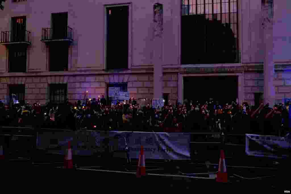 2022年6月4日,示威者傍晚在中國駐英大使館對面馬路的英國皇家建築師學會(Royal Institute of British Architects)大樓外的行人道上舉行燭光守夜。(美國之音鄭樂捷)