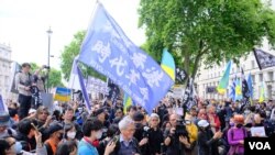 2022年6月4日在伦敦举行的六四事件纪念集会上，来自香港的示威者手持“光复香港，时代革命”的旗帜与支持乌克兰的示威者一起集会。 （美国之音/郑乐捷）